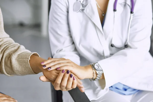 Woman doctor calms patient and holds hand — Stock Photo, Image