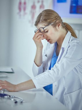 Genç kadın doktor bilgisayar ile çalıştıktan sonra yorgun
