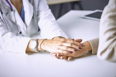 Kadın doktor hastayı sakinleştirir ve elini tutar