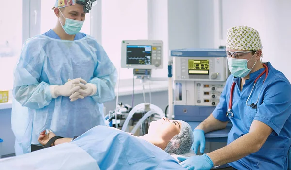 T sırasında ameliyat masasında hasta çevreleyen birkaç doktor