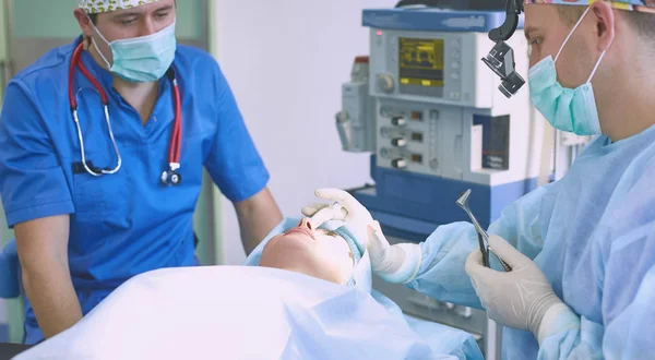 Several doctors surrounding patient on operation table during t — Stock Photo, Image