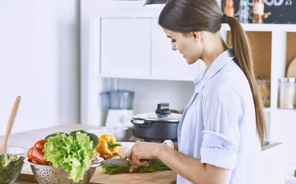 若い女性は、台所で食べ物を準備します。健康食品 - 野菜 — ストック写真