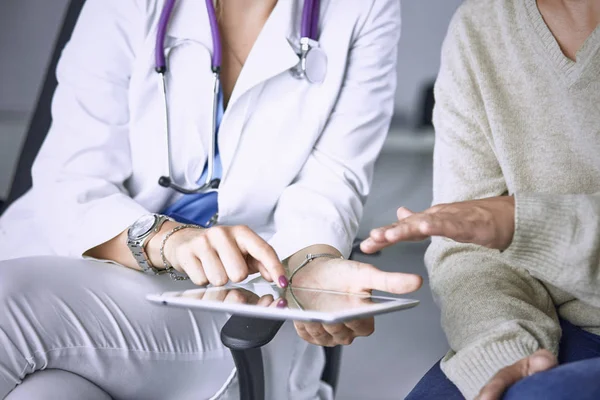 female doctor talking to a patient on a tablet