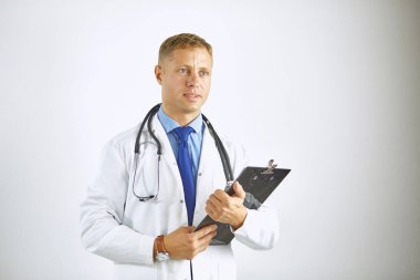 Steteskoplu beyaz önlüklü, kendine güvenen genç bir doktor.
