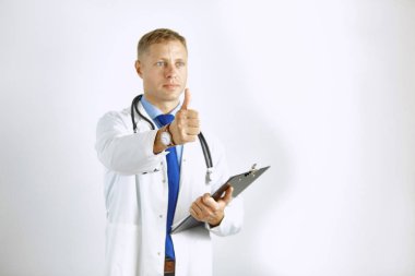 Steteskoplu beyaz önlüklü, kendine güvenen genç bir doktor.