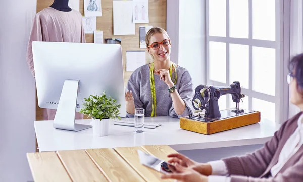 Attraktive Modedesignerin, die im Büro arbeitet, am Schreibtisch lehnt, zeichnet — Stockfoto