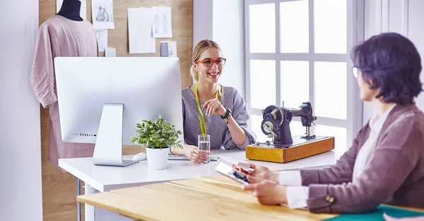 Hübsche Schneiderin zeigt ihrem Kunden ein neues Design — Stockfoto