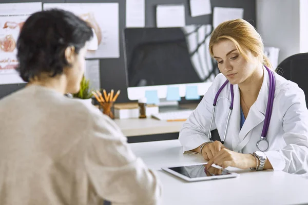 Jeune femme médecin prend patient dans le bureau — Photo