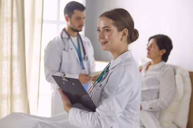 Doktor, arka planda bir grup hastada