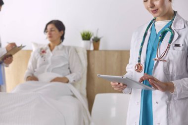 Doktor, arka planda bir grup hastada