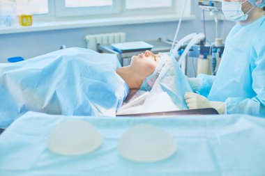Birkaç doktor hasta operasyon masası üzerinde onların çalışma sırasında çevreleyen. Takım cerrahlar ameliyathane içinde işte