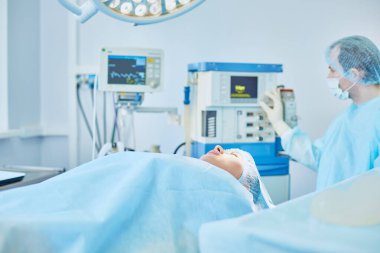 Birkaç doktor hasta operasyon masası üzerinde onların çalışma sırasında çevreleyen. Takım cerrahlar ameliyathane içinde işte