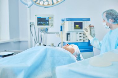 Birkaç doktor hasta operasyon masası üzerinde onların çalışma sırasında çevreleyen. Takım cerrahlar ameliyathane içinde işte