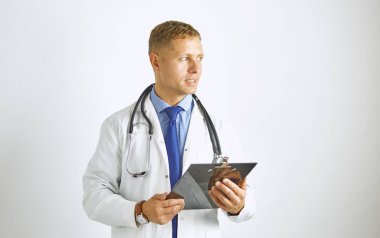 Steteskoplu beyaz önlüklü, kendine güvenen genç bir doktor.