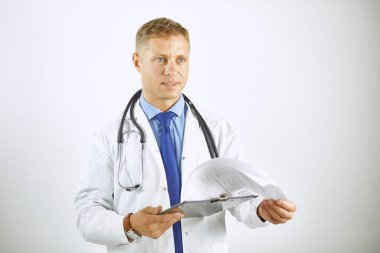 Steteskoplu beyaz önlüklü, kendine güvenen genç bir doktor.