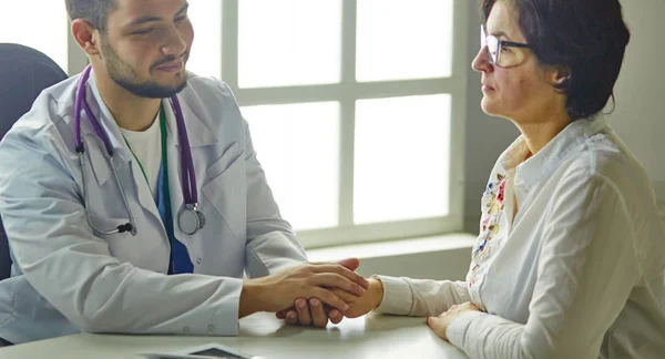 Giovane medico che parla con un paziente in ufficio — Foto Stock