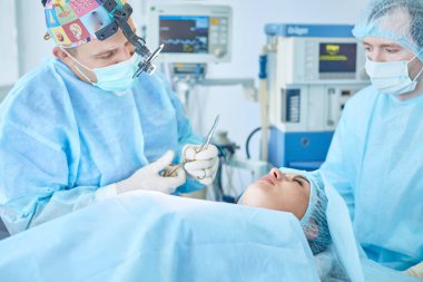 Birkaç doktor hasta operasyon masası üzerinde onların çalışma sırasında çevreleyen. Takım cerrahlar ameliyathane içinde işte