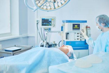Birkaç doktor hasta operasyon masası üzerinde onların çalışma sırasında çevreleyen. Takım cerrahlar ameliyathane içinde işte