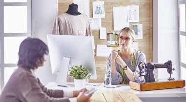 Güzel terzi müşterisine yeni bir tasarım gösteriyor