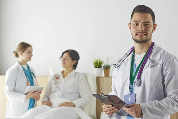 Paziente con un gruppo di medici sullo sfondo — Foto Stock