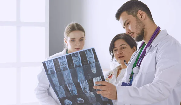 Läkare tittar på röntgenfotografering av äldre kvinna — Stockfoto