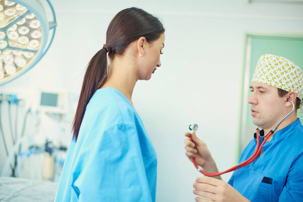 The girl, who wants to correct sagging breasts, at the reception at the plastic surgeon. She tries on the desired breast using a silicone mold