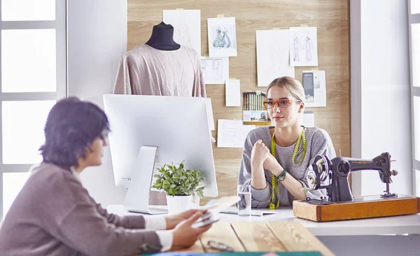 Bonita modista mostrando un nuevo diseño a su cliente — Foto de Stock