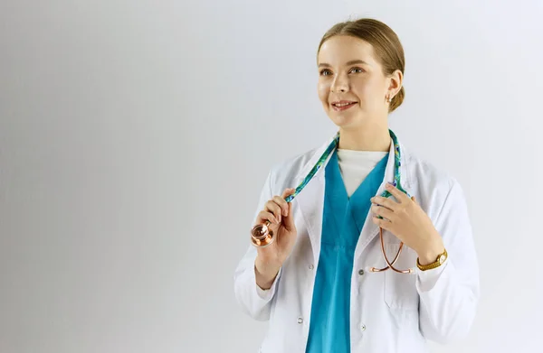 Женщина-врач со стетоскопом стоит в кабинете — стоковое фото