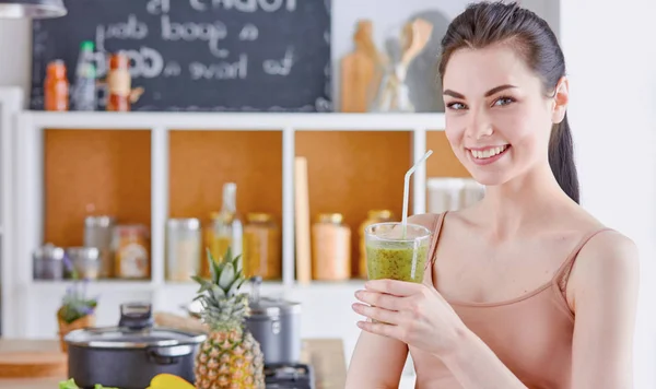 A young girl drinks a cocktail on a kitchen — Stock Photo, Image