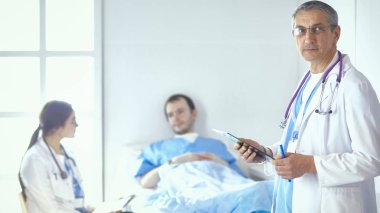 Doktor stetoskop ile yatakta hasta kalp ritmini kontrol