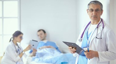 Doktor stetoskop ile yatakta hasta kalp ritmini kontrol