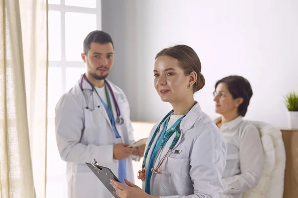 Pacient se skupinou lékařů na pozadí — Stock fotografie