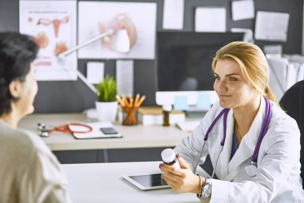 Junge Ärztin nimmt Patientin ins Büro — Stockfoto