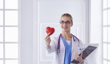 Kalbi tutan steteskoplu bir doktor, beyaz arka planda izole edilmiş.