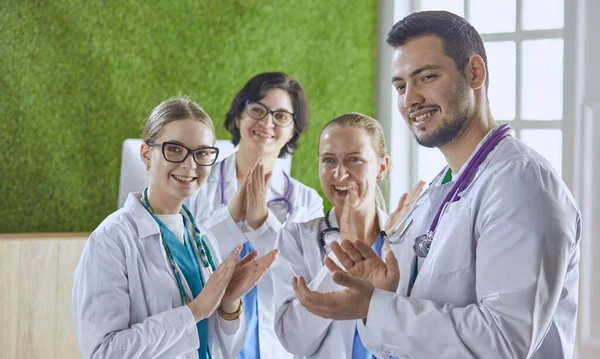 Happy medical team comprising male and female doctors smiling broadly and giving a thumbs up of success and hope — Stock Photo, Image