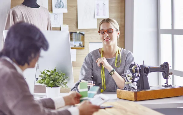 Bonita modista mostrando un nuevo diseño a su cliente — Foto de Stock