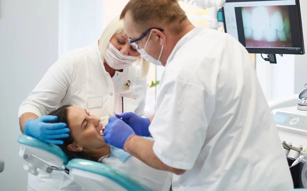 Zahnarzt behandelt Zähne einer schönen jungen Patientin. Das Mädchen an der Rezeption beim Zahnarzt. Zahnarzt behandelt Zahn — Stockfoto