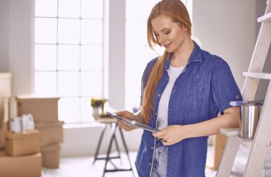 Beyaz tahta bir merdiven üzerinde güzel bir genç kadın. Odayı onarmaya hazırız. Kadın ev işi konsepti