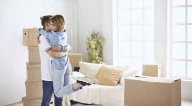 Mutlu genç çift yeni evlerinin anahtarlarını gösteriyor.