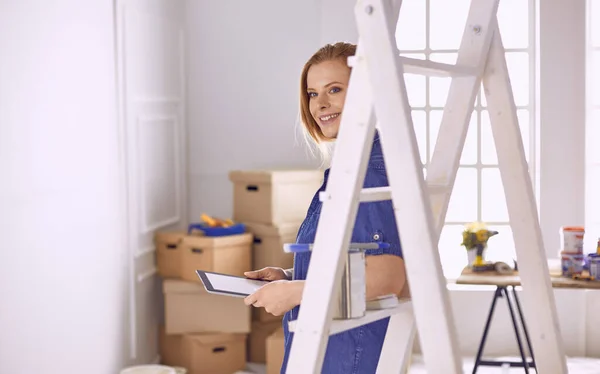 Vacker ung kvinna på en vit trappstege i trä. Redo att reparera rummet. Begreppet hushållsarbete för kvinnor — Stockfoto