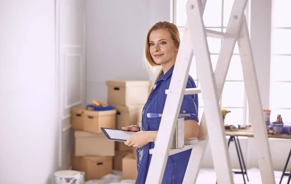 Bella giovane donna su una scala di legno bianca. Pronto a riparare la stanza. Donne concetto di lavori domestici — Foto Stock