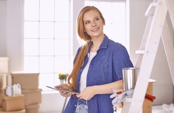 Vacker ung kvinna på en vit trappstege i trä. Redo att reparera rummet. Begreppet hushållsarbete för kvinnor — Stockfoto