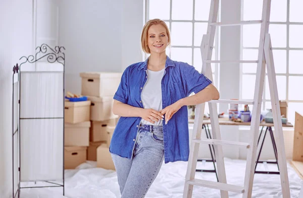 Schöne junge Frau auf einer weißen Holzleiter. Bereit, den Raum zu reparieren. Frauenhaushaltskonzept — Stockfoto