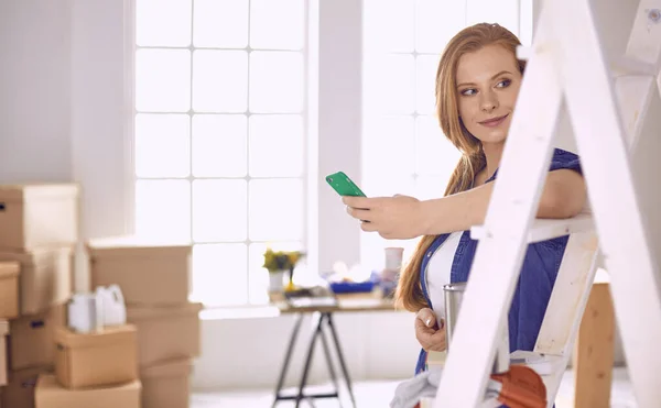 Bella giovane donna su una scala di legno bianca. Pronto a riparare la stanza. Donne concetto di lavori domestici — Foto Stock