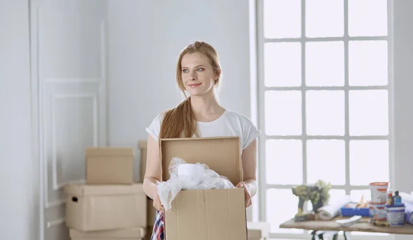 Красивая одинокая девушка распаковывает коробки и переезжает в новый дом — стоковое фото