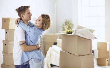 Mutlu genç çift yeni evlerinin anahtarlarını gösteriyor.