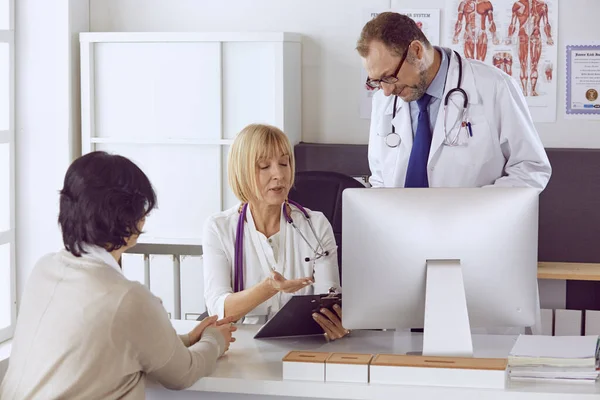 Orta yaşlı erkek doktor bir meslektaşının çalışmasına eşlik ediyor. — Stok fotoğraf