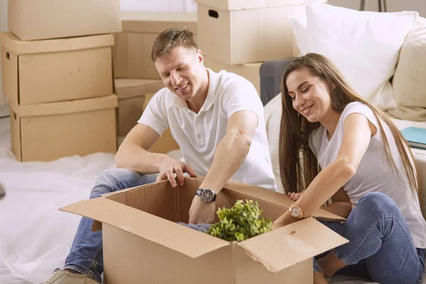 새 집에서 노트북 컴퓨터를 함께 보고 있는 행복 한 커플의 사진 상자로 둘러싸인 채 — 스톡 사진