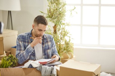Taşındıktan sonra yeni dairede kutuları olan yakışıklı bir adam.