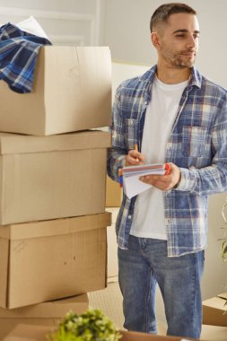 Taşındıktan sonra yeni dairede kutuları olan yakışıklı bir adam.